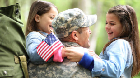 Military Father holding daughters