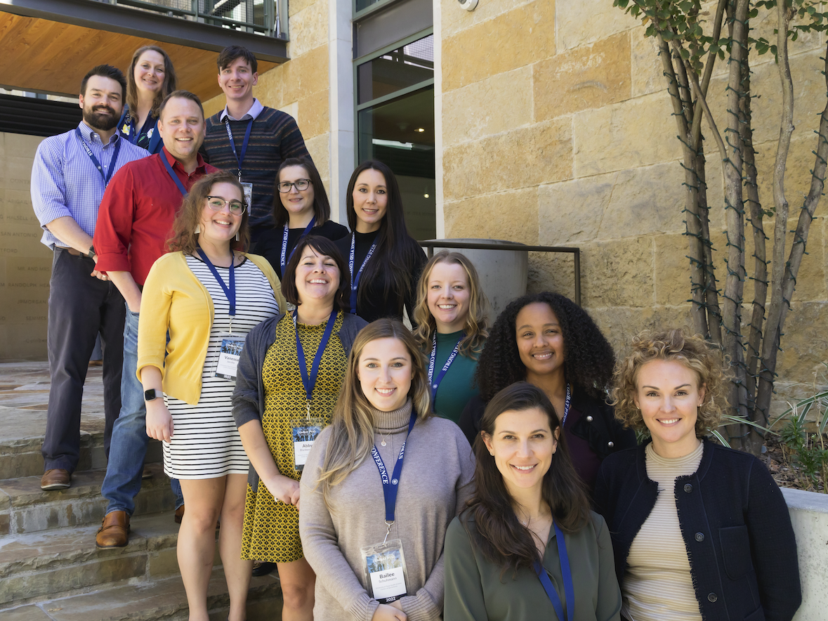 Image of Strong Star Training Initiative team on stairs. From top left to bottom right: Dr. Casey Straud, Jenny Postich, Will Price, Dr. John Moring, Elisa Medellin, Dr. Vanessa Jacoby, Dr. Hunter Hansen, Dr. Abby Blankenship, Dr. Hannah Tyler, Dr. Bailee Schuhmann, Dr. Hall-Clark, Brooke Fina, Dr. Katy Dondanville.